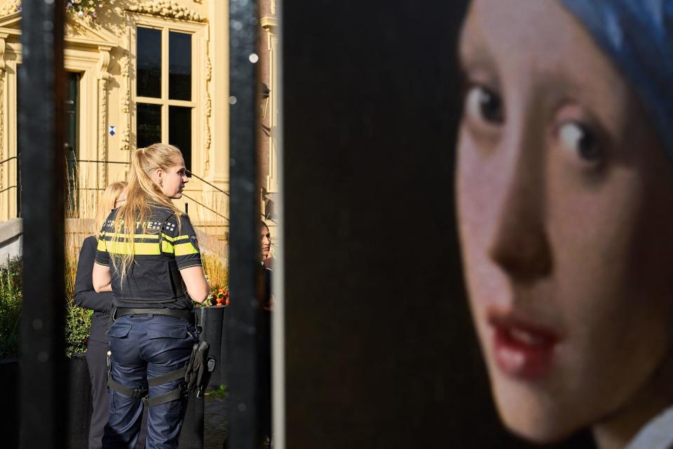 A police woman stands guard outside the Mauritshuis museum after an attempt to smear the Johannes Vermeer's painting 