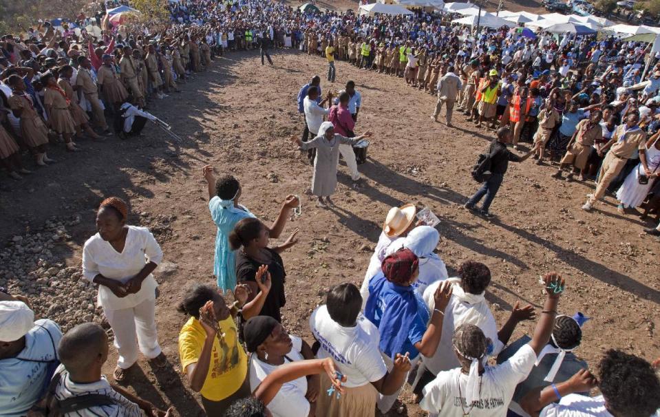 In this Feb. 8, 2014 photo, Christian pilgrims pray on a mountain top during a religious gathering organized by Our Lady of Fatima Bible Center in the village of Bois-Neuf, Haiti. Faithful came to the barren mountainside in central Haiti by the thousands, seeking favors and spiritual renewal. (AP Photo/Dieu Nalio Chery)