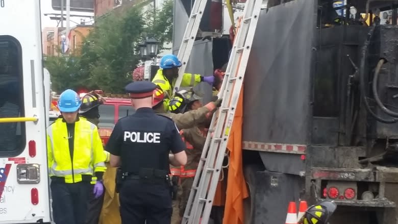 Firefighters and paramedics free injured worker from hot tar truck in Toronto