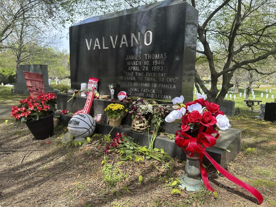 The grave of charismatic North Carolina State men’s basketball coach Jim Valvano, adorned with flowers and numerous Wolfpack-related tributes, is shown at Oakwood Cemetery in Raleigh, N.C., Monday, April 1, 2024. N.C. State’s men’s basketball team is in the Final Four for the first time since 1983, while the Wolfpack women are in the Final Four for the first time since 1998. (AP Photo/Aaron Beard)