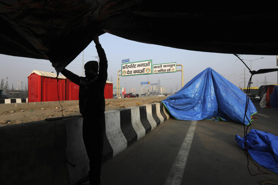 An Indian Farmer pitches his tent on the side of a highway, as they continue to block a highway leading to Delhi in protest against new farm laws, at Delhi-Uttar Pradesh border, India, Friday, Jan. 22, 2021. Talks between protesting farmers’ leaders and the government ended abruptly in a stalemate on Friday with the agriculture minister saying he has nothing more to offer than suspending contentious agricultural laws for 18 months. The farmers’ organizations in a statement on Thursday said they can’t accept anything except the repeal of the three new laws. (AP Photo/Manish Swarup)
