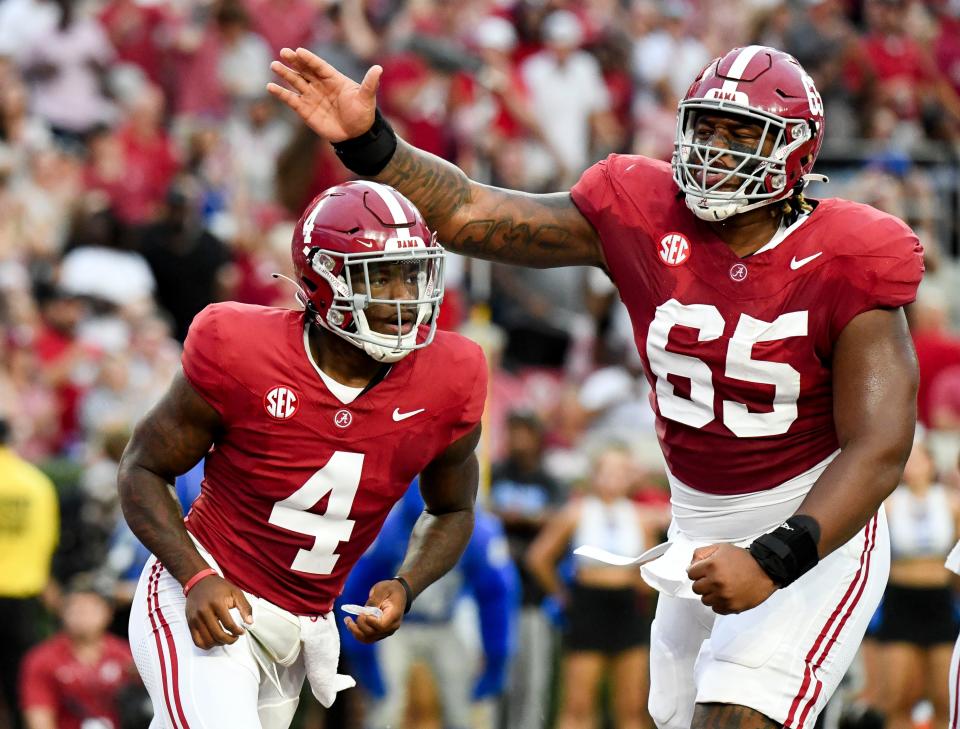 Sep 2, 2023; Tuscaloosa, Alabama, USA; Alabama Crimson Tide offensive lineman JC Latham (65) congratulates Alabama Crimson Tide quarterback Jalen Milroe (4) after Milroe scored against MTSU at Bryant-Denny Stadium. Mandatory Credit: Gary Cosby Jr.-USA TODAY Sports