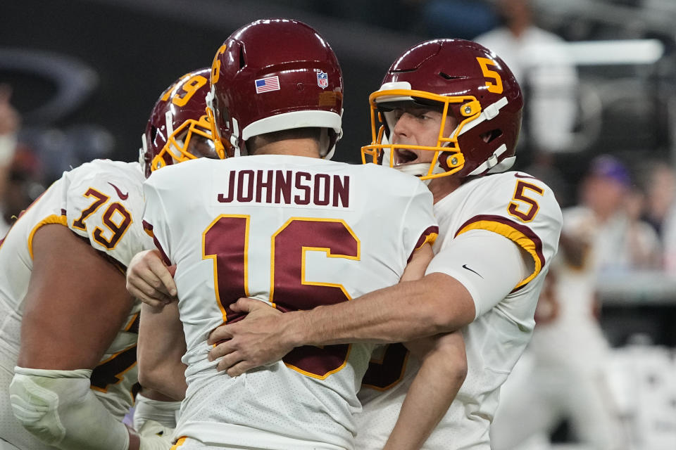 Washington Football Team's Tress Way (5) embraces kicker Brian Johnson after Johnson made a 48-yard field goal against the Las Vegas Raiders during the second half of an NFL football game, Sunday, Dec. 5, 2021, in Las Vegas. (AP Photo/Rick Scuteri)