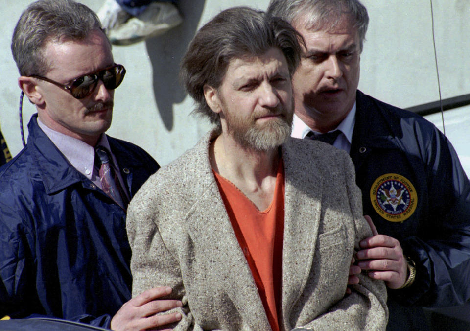 FILE - In this April 4, 1996 file photo, Ted Kaczynski, better known as the Unabomber, is flanked by federal agents as he is led to a car from the federal courthouse in Helena, Mont. Kaczynski, known as the “Unabomber,” has died in federal prison, a spokesperson for the Bureau of Prisons told The Associated Press on Saturday, June 10, 2023. (AP Photo/John Youngbear, File)