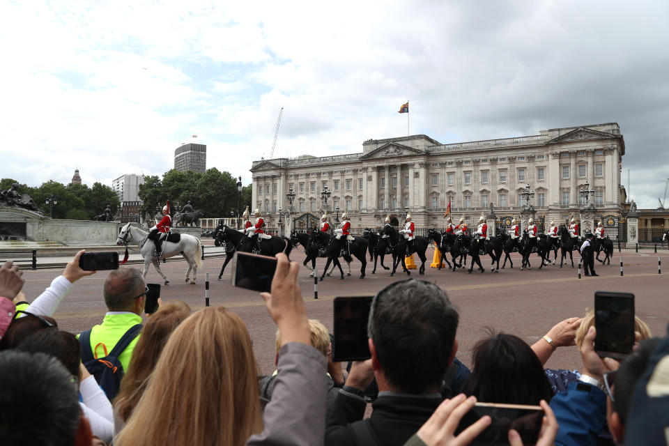 Tourists watch as the Household Cavalry make their way down to Horse Guards Parade from Buckingham Palace, London, during the first day of a state visit to the UK by US President Donald Trump.