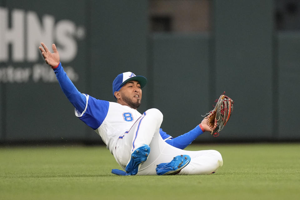 Atlanta Braves left fielder Eddie Rosario (8) makes a sliding catch on a fly ball by San Diego Padres' Ha-Seong Kim during the second inning of a baseball game Saturday, April 8, 2023, in Atlanta. (AP Photo/John Bazemore)