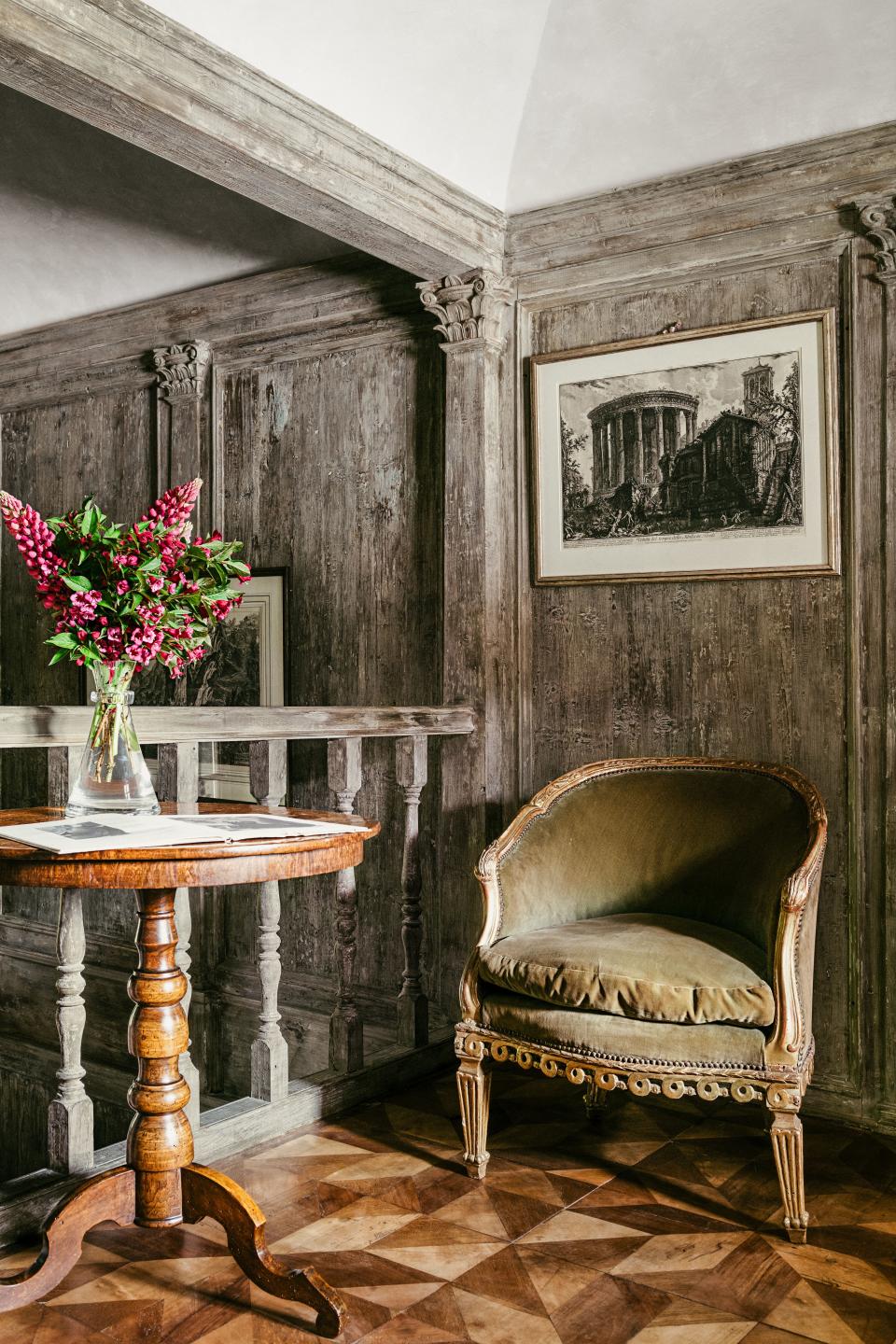 An 18th-century Italian gilded bergère faces a walnut table on the first-floor landing.