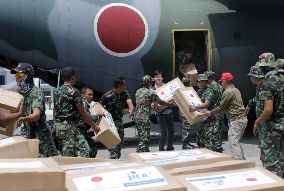 In this Saturday, Oct. 6, 2018, file photo, Indonesian and Japanese military personnel unload relief aid from a Japan Air Force cargo plane at the Mutiara Sis Al-Jufri airport in Palu, Central Sulawesi, Indonesia. (AP Photo/Tatan Syuflana, File)