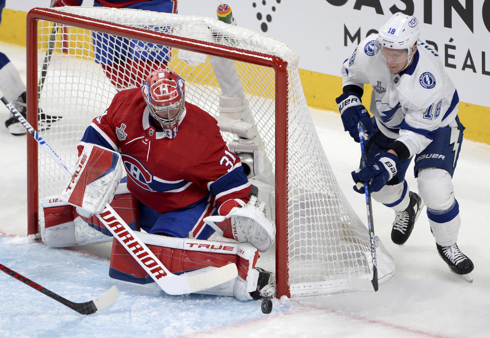 Montreal Canadiens' goaltender Carey Price (31) watches the puck as Tampa Bay Lightning's Ondrej Palat (18) chases during the first period of Game 4 of the NHL hockey Stanley Cup final in Montreal, Monday, July 5, 2021. (Ryan Remiorz/The Canadian Press via AP)