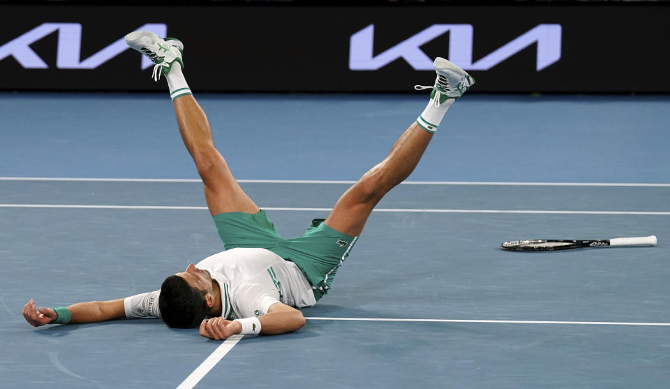 Serbia's Novak Djokovic falls as he celebrates after defeating Russia's Daniil Medvedev in the men's singles final at the Australian Open tennis championship in Melbourne, Australia, Sunday, Feb. 21, 2021.(AP Photo/Mark Dadswell)