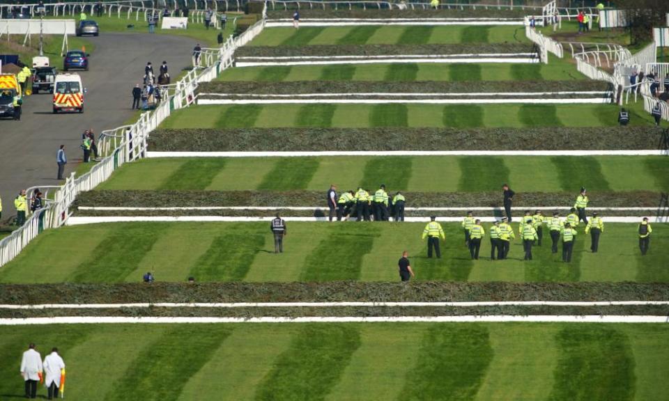 Police officers respond to Animal Rising activists attempting to invade the race course ahead of the Grand National at Aintree.