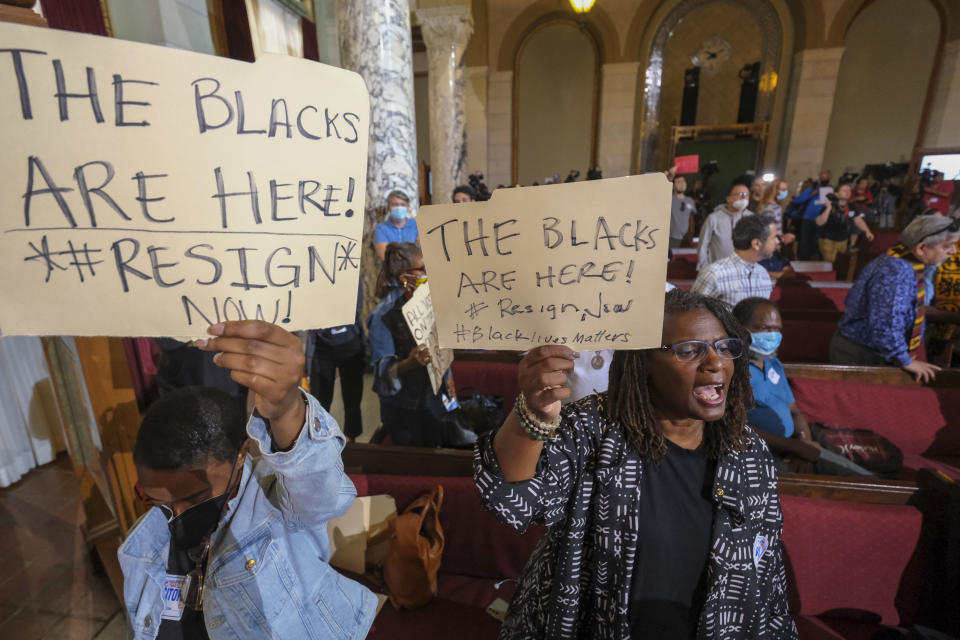 FILE - People hold signs and shout slogans before the starting the Los Angeles City Council meeting on Tuesday, Oct. 11, 2022 in Los Angeles. Cross-cultural coalitions have ruled Los Angeles politics for decades, helping elect both Black and Latino politicians to top leadership roles in the racially and ethnically diverse second largest city in America. But the year old recording of racist comments by the city's City Council president has laid bare the tensions over political power that have long quietly simmered between the Latino and Black communities. (AP Photo/Ringo H.W. Chiu, File)