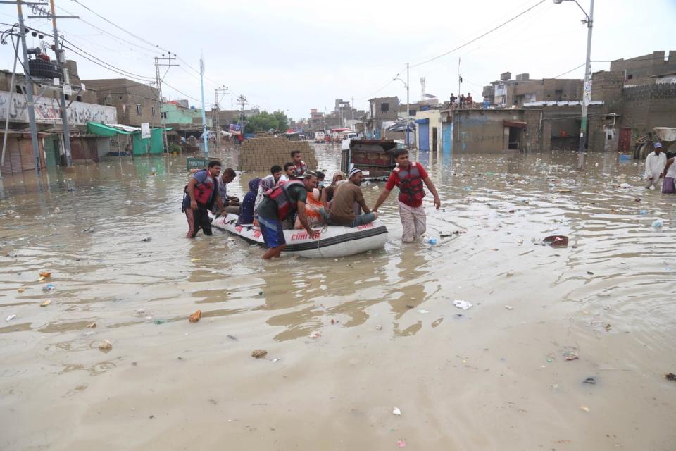 Rescue personnel evacuate people in a boat after heavy monsoon rains in Karachi (EPA)