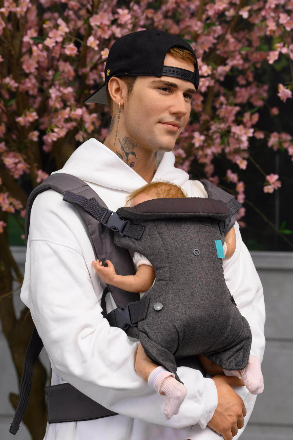 Caption: Baby, Baby, Baby, Oh! In celebration of Justin and Hailey Bieber's baby news Madame Tussauds London has dressed the dad-to-be with a baby carrier to help him get some all-important practice in ahead of the big arrival. Fans of the 'Baby' superstar can see the figure at the Baker Street attraction.