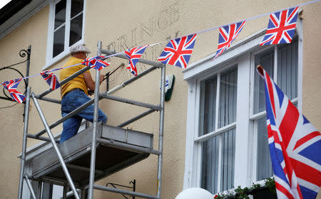 <span>Un trabajador pinta el nuevo nombre en un pub en honor de la boda del Príncipe Harry y Meghan Markle, en Windsor, Gran Bretaña, el 16 de mayo de 2018. Crédito: REUTERS / Phil Noble</span>