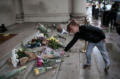 A young boy leaves flowers in tribute to victims of Paris attacks outside the French Embassy in London. Photo: Reuters