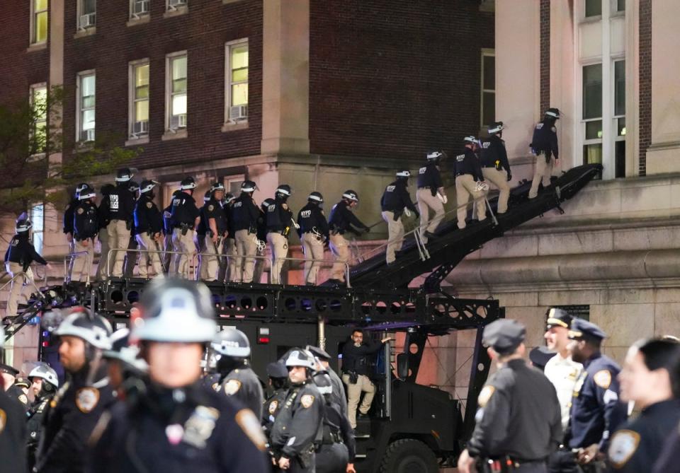 NYPD officers use a tactical ramp to break into Hamilton Hall, which had been renamed Hind Hall by protesters occupying the building (EPA)