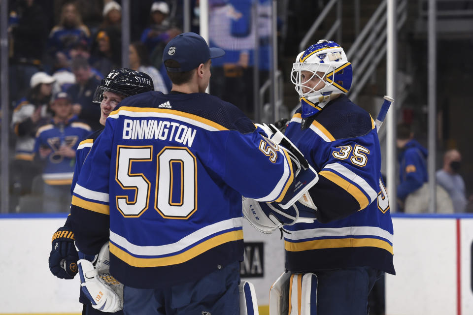 St. Louis Blues goaltender Jordan Binnington (50) and goaltender Ville Husso (35) celebrate their team's victory over the Calgary Flames in an NHL hockey game Thursday, Jan. 27, 2022, in St. Louis. (AP Photo/Joe Puetz)