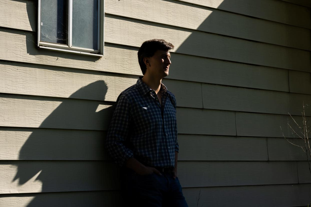 Shadow across Jan Sramek's face in front of a house.