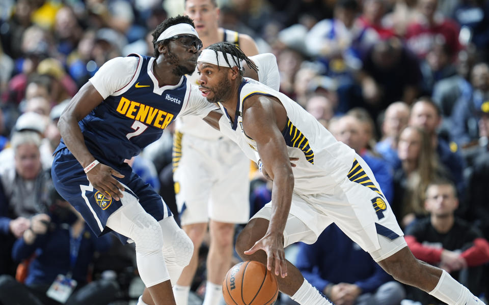 Indiana Pacers guard Buddy Hield, right, drives past Denver Nuggets guard Reggie Jackson, left, in the second half of an NBA basketball game Sunday, Jan. 14, 2024, in Denver. (AP Photo/David Zalubowski)