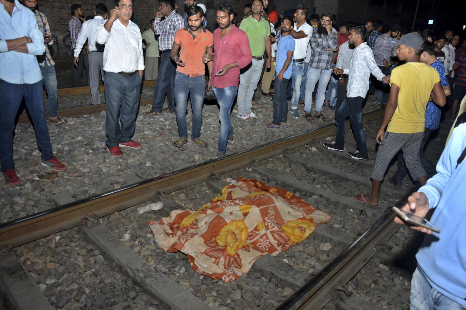 The body of a victim of a train accident lies covered in cloth on a railway track in Amritsar, India, Friday, Oct. 19, 2018. A speeding train ran over a crowd watching fireworks during a religious festival in northern India on Friday, killing at least 50 people, a Congress party leader said. (AP Photo/Prabhjot Gill)