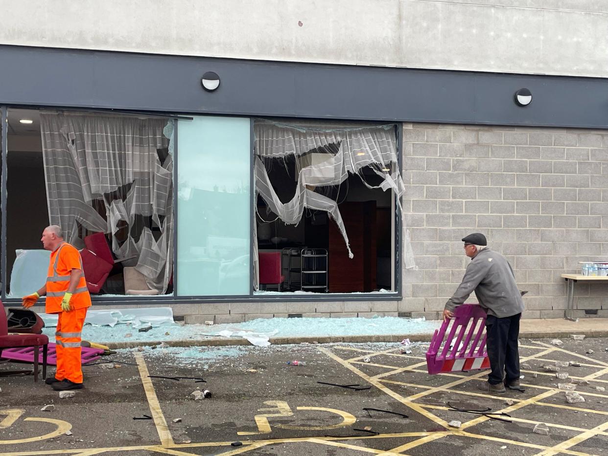 People clear debris at the Holiday Inn Express in Rotherham, South Yorkshire, where anti-immigration rioters smashed the windows before starting fires on Sunday. At least 10 officers were injured, including one who was knocked unconscious, South Yorkshire Police confirmed later, saying one person had already been arrested and others involved should 