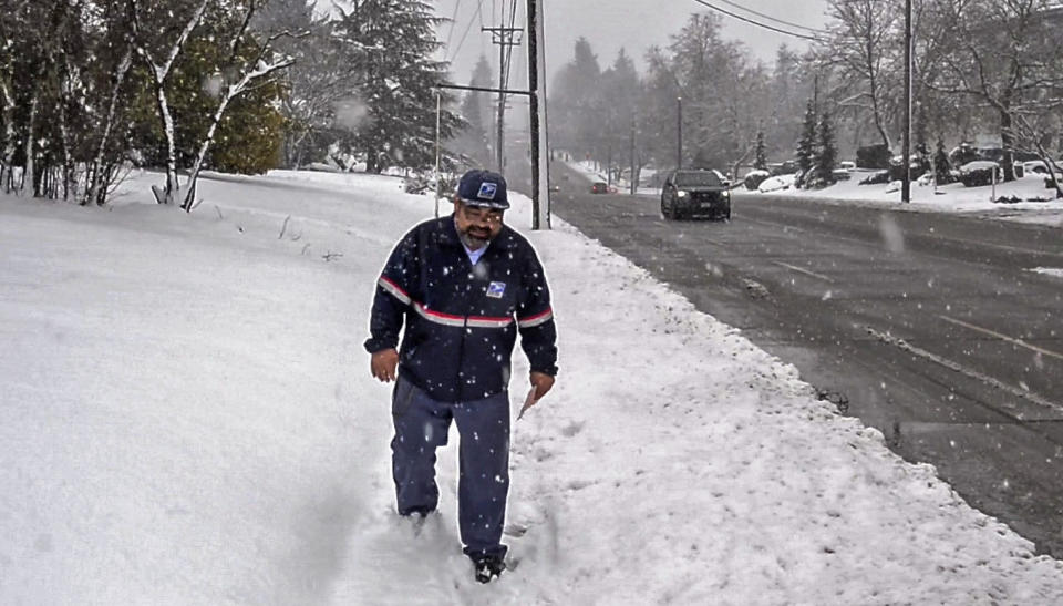 Postal carrier Tom Arndt delivers letters to homes along South 19th Street in Tacoma, Wash., Monday, Feb. 11, 2019. (Peter Haley/The News Tribune via AP)