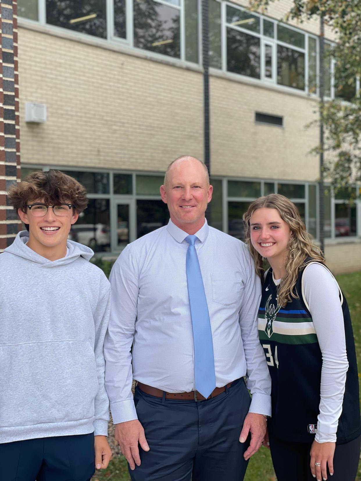 Brookfield East High School Principal Andrew Farley (middle) smiles with juniors Tyler Kloida (left) and Hannah Christianson (right) outside their school. Farley is one of three finalists up for National Principal of the Year, which will be announced on Oct. 20.