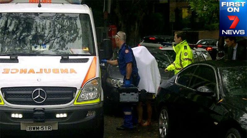 FIRST ON 7: Paramedics escort a woman into an ambulance at the scene of the fatal stabbing in Darling Point.