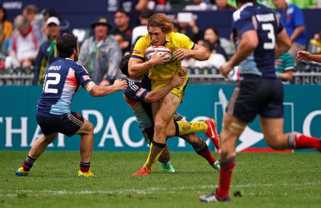 Australia's Jesse Parahi (front C) is tackled by France's Vincent Inigo (12), Julien Candelon and Jean Baptiste Mazoue (3) during the second day of the three-day Hong Kong Sevens rugby tournament, as part of the Sevens World Series, in Hong Kong March 29, 2014. REUTERS/Tyrone Siu