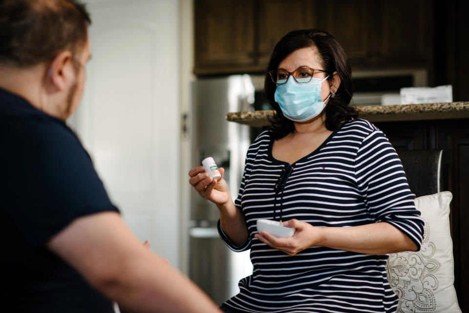 Image: Mauricio Marin's wife, Daysi, helps him with his daily medications. (Brandon Thibodeaux / for NBC News)