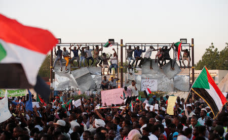 Sudanese protesters wave national flags and shout slogans as they gather for a mass protest in front of the Defence Ministry in Khartoum, Sudan, April 21, 2019. REUTERS/Umit Bektas