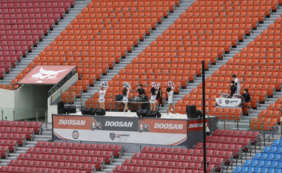 Doosan Bears' cheerleaders perform for their team in the empty seats as a precautionary measure during the KBO league baseball game between KT Wiz and Doosan Bears in Seoul, South Korea, Sunday, Aug. 16, 2020. Fans are banned once again from professional baseball and soccer games, which had just begun to slowly bring back spectators in late July. (AP Photo/Lee Jin-man)