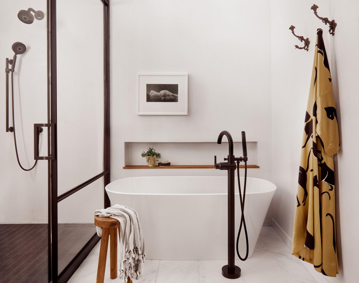  A freestanding bath with a side table . 