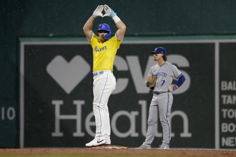 Boston Red Sox's Adam Duvall gestures toward the dugout after hitting an RBI double against the Kansas City Royals during the fifth inning of a baseball game, as Royals shortstop Bobby Witt Jr. looks away at Fenway Park, Thursday, Aug. 10, 2023, in Boston. (AP Photo/Mary Schwalm)