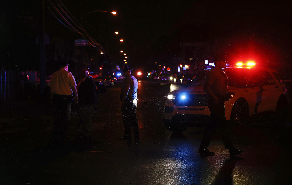 Philadelphia police stand at the intersection of 56th Street and Kingsessing Avenue after multiple people were shot in Southwest Philadelphia, late Monday, July 3, 2023. (Yong Kim/The Philadelphia Inquirer via AP)