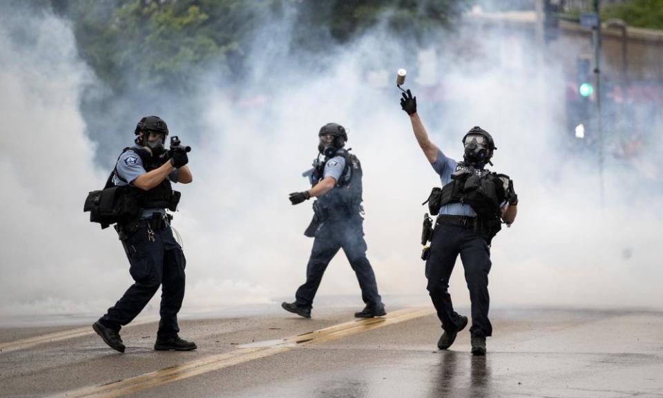 A police officer throws a teargas canister towards protesters in Minneapolis, Minnesota, on 26 May.