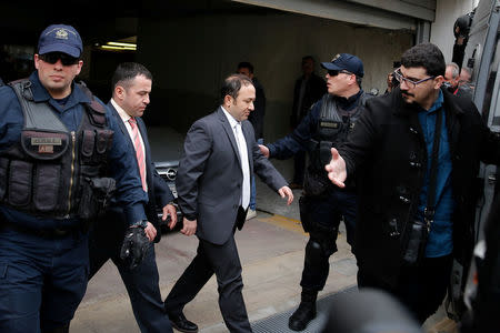 Two of the eight Turkish soldiers, who fled to Greece in a helicopter and requested political asylum after a failed military coup against the government, are escorted by police officers as they leave the appeals court in Athens, Greece, March 16, 2018. REUTERS/Costas Baltas