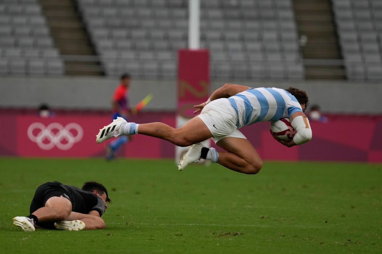 Argentina's Rodrigo Isgro goes flying after a tackle by New Zealand's Andrew Knewstubb in their men's rugby sevens match at the 2020 Summer Olympics, Monday, July 26, 2021, in Tokyo, Japan.