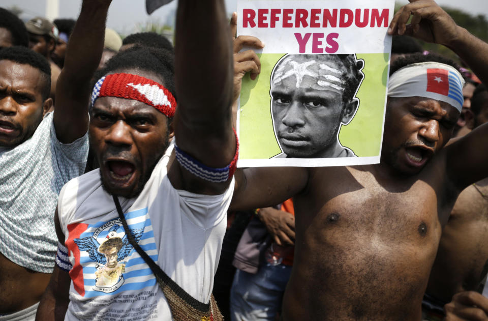A Papuan activist displays a banner demanding referendum during a rally near the presidential palace in Jakarta, Indonesia, Thursday, Aug. 22, 2019. A group of West Papuan students in Indonesia's capital staged the protest against racism and called for independence for their region. (AP Photo/Dita Alangkara)