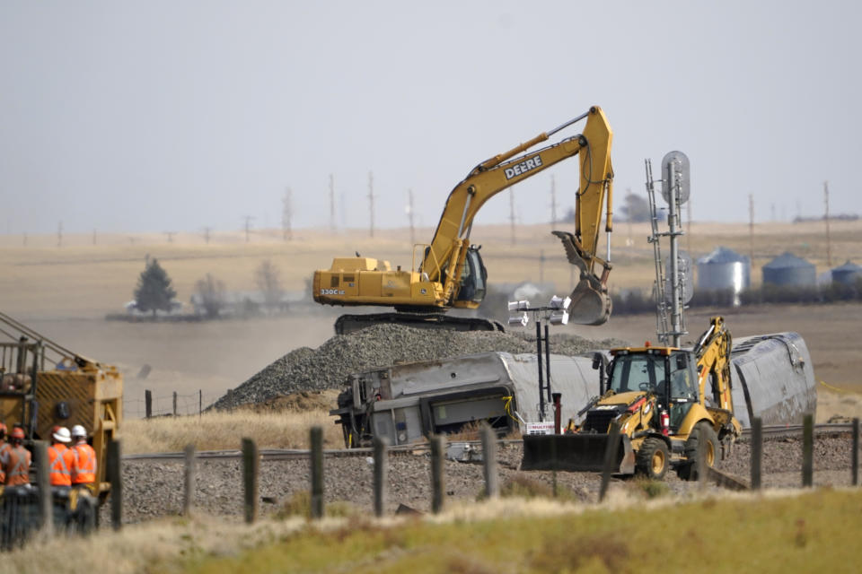 Heavy equipment moves gravel Sunday, Sept. 26, 2021, next to cars from an an Amtrak train that derailed Saturday just west of Joplin, Mont. The westbound Empire Builder was en route to Seattle from Chicago, with two locomotives and 10 cars. (AP Photo/Ted S. Warren)