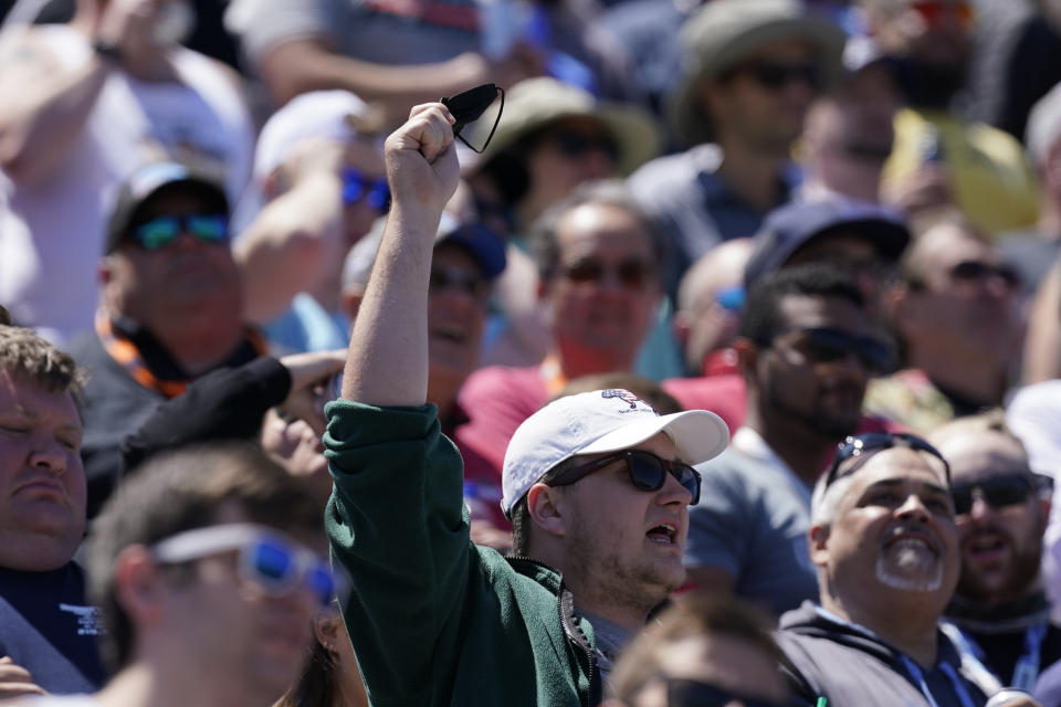 A fan holds his face mask as he sings "Back Home Again In Indiana" before the Indianapolis 500 auto race at Indianapolis Motor Speedway, Sunday, May 30, 2021, in Indianapolis. (AP Photo/Darron Cummings)