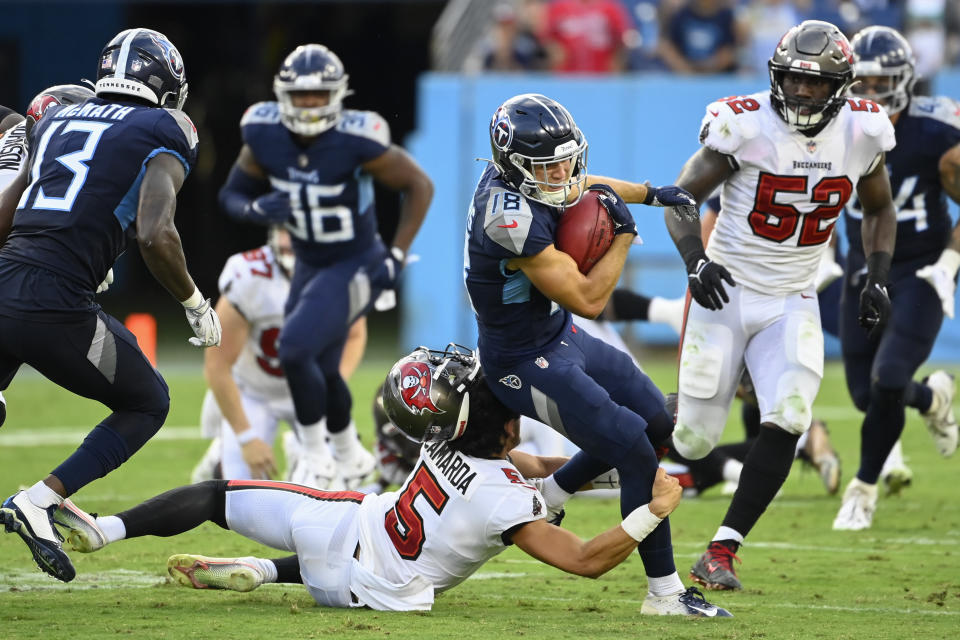 Tampa Bay Buccaneers punter Jake Camarda (5) loses his helmet as he tries to bring down Tennessee Titans kick returner Kyle Philips (18) in the first half of a preseason NFL football game Saturday, Aug. 20, 2022, in Nashville, Tenn. (AP Photo/Mark Zaleski)