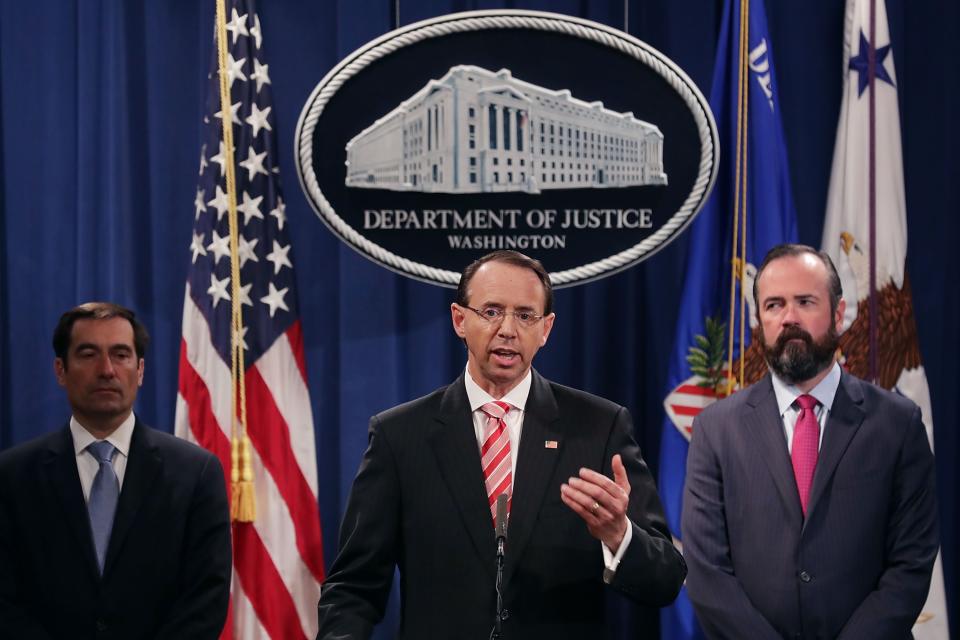 Assistant Attorney General John Demers (L) announces charges July 13, 2018, against 12 Russian intelligence agents for hacking computers used by the Democratic National Committee, with Deputy Attorney General Rod Rosenstein (C) and Acting Principal Deputy Attorney General Edward O'Callaghan (R).