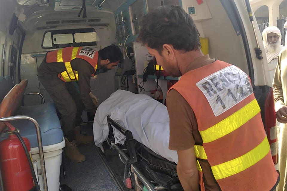 Rescue workers load a body of a police officer, who was killed in a militant attack, into an ambulance at a hospital in Tank, Pakistan, Friday, Dec. 15, 2023. Militants staged attacks on a regional police headquarters and an army post in a former Taliban stronghold in northwest Pakistan before dawn Friday, triggering firefights that killed a few police officers and three insurgents, security officials said. (AP Photo)