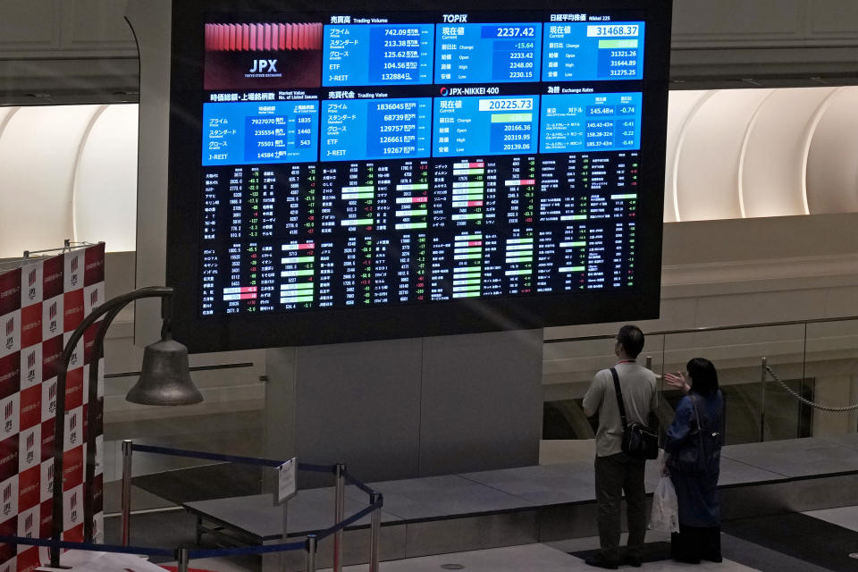 FILE - Visitors look at an electronic stock board at Tokyo Stock Exchange on Aug. 18, 2023 in Tokyo, Japan. Asian shares advanced Friday, Sept. 15, with solid gains for Chinese markets after the central bank eased the reserve requirements for banks to encourage more lending and prop up the slowing economy. (AP Photo/Shuji Kajiyama, File)