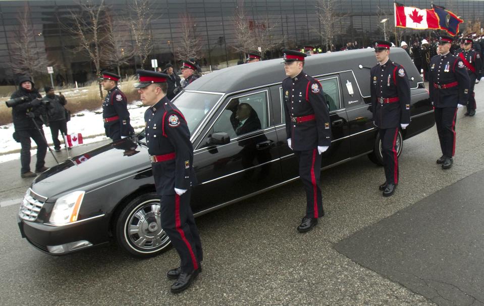 Police officers escort the hearse arriving at the public memorial for police constable John Zivcic in Toronto December 9, 2013. Zivcic died December 2, from injuries he sustained in a car crash while in pursuit of another vehicle. He was Toronto's 26th officer to die while on duty since the Toronto police force began in 1957. REUTERS/Fred Thornhill (CANADA - Tags: OBITUARY CRIME LAW)