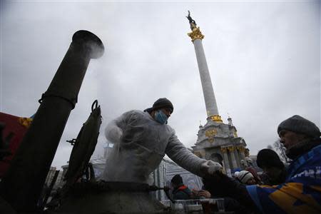A man distributes tea to protesters at Independence Square in Kiev December 7, 2013. REUTERS/Stoyan Nenov