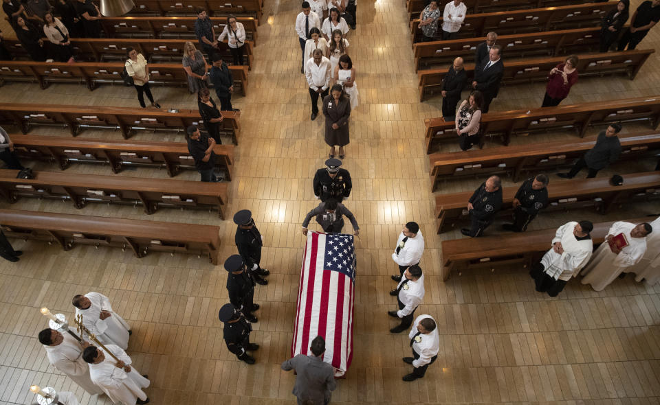 Pallbearers wait as an American flag is place on casket during funeral mass of slain LAPD officer Juan Diaz at the Cathedral of Our Lady of the Angels in Los Angeles, Calif., on Monday, Aug. 12, 2019. (Brian van der Brug /Los Angeles Times via AP, Pool)