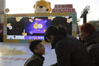 In this photo taken Sunday, Nov. 10, 2019, a child reacts after taking part in a promotion ahead of Nov. 11 Singles day in Beijing. Chinese online shoppers hunt bargains on Singles Day, a holiday invented in the 1990s that has become the world's busiest day for online commerce. (AP Photo/Ng Han Guan)